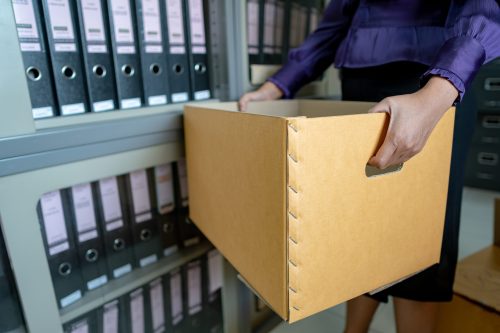 The hand of a woman holds important documents in the office.